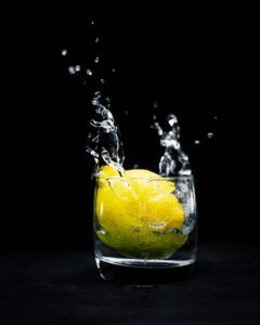dropping lemon in a glass
